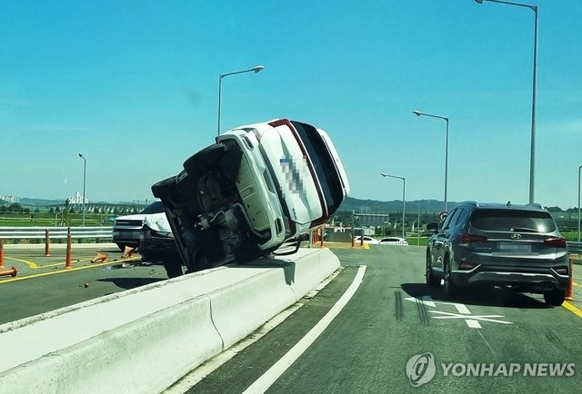 사고로 중앙분리대 위까지 밀려난 승합차