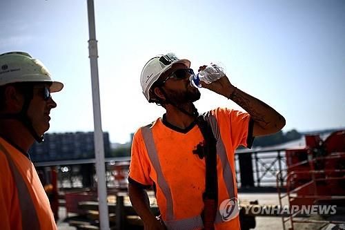 2025년 6월 30일 프랑스 남서부 보르도에서 폭염이 계속되는 가운데 한 노동자가 퐁 드 피에르 다리 보강 현장에서 더위를 식히기 위해 물을 마시고 있다.[AFP 연합뉴스 자료사진. 재판매 및 DB 금지]