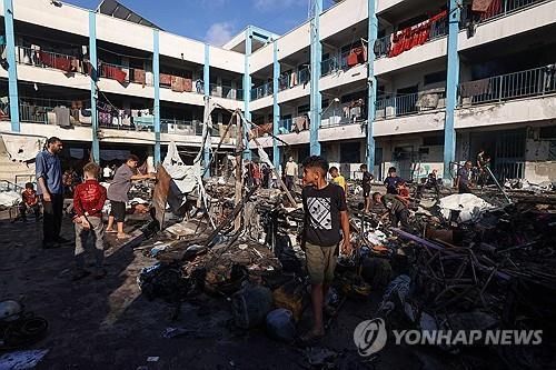 가자지구 중부의 이스라엘 공습 현장 둘러보는 팔레스타인 피란민들