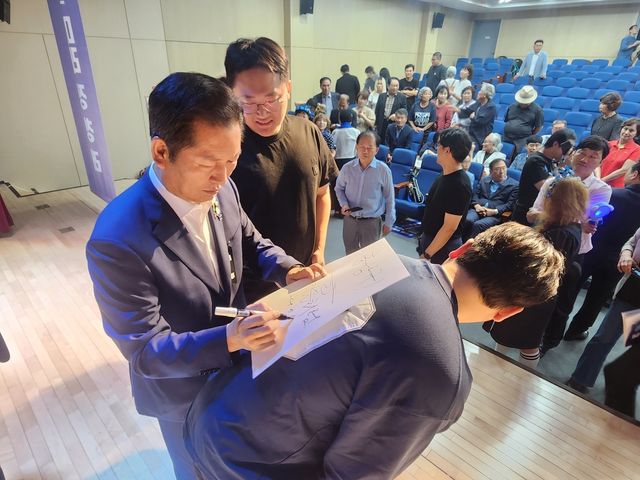 지지자들에게 서명해주고 있는 정청래 후보