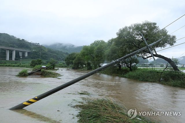 도로와 함께 위태롭게 내려앉은 전봇대