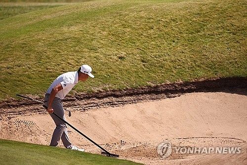 연습 라운드 도중 벙커를 정리하는 콜린 모리카와.