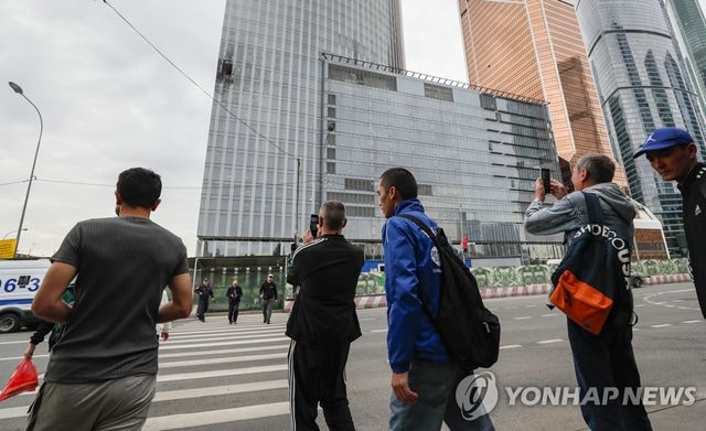 모스크바서 드론 충돌한 건물 사진 찍는 시민들