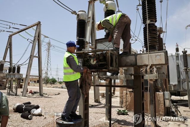 지난 5월 26일 시리아 다마스쿠스 인근 알 키스와 지역에서 근로자들이 발전용 변압기를 정비하는 모습.[로이터=연합뉴스. 재판매 및 DB 금지]