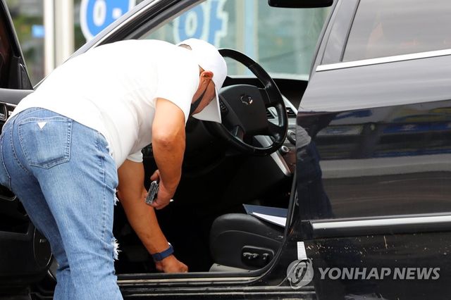 침수된 차 살펴보는 중고차 상인