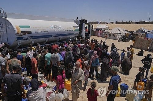 지난 19일(현지시간) 가자지구 남부 칸유니스 구호소 물탱크 트럭 앞에 물을 받으려고 모인 팔레스타인 주민들.[AP=연합뉴스. 재판매 및 DB 금지]