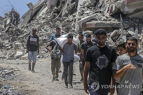 구호품 받아 이동하는 가자지구 주민들