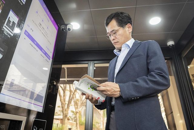 스마트도서관 기기에서 책을 대출하는 이기재 양천구청장
