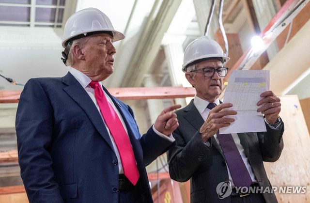 24일(현지시간) 미국 워싱턴DC 연준 본부를 방문한 도널드 트럼프 미국 대통령(왼쪽) 제롬 파월 연준 의장과 대화하며 비용 내역서를 가리키고 있다.[AFP=연합뉴스. 재판매 및 DB 금지]