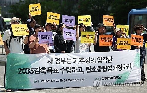 기후위기비상행동이 지난달 11일 서울 종로구 광화문광장에서 연 '2035 감축목표 수립 및 탄소중립법 개정 촉구 기자회견'에서 참가자들이 손팻말을 들고 있다. [연합뉴스 자료사진] 