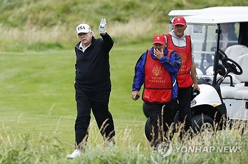 턴베리 골프클럽에서 골프를 치다 사람들에게 손을 흔드는 트럼프 대통령.