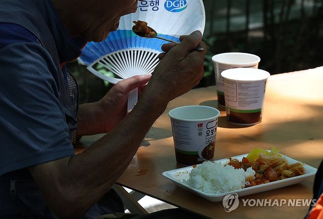 부채 들고 식사하는 어르신