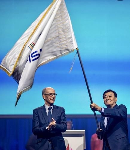 대회기를 받고 흔드는 강창희 충청 U대회 조직위원장(오른쪽)