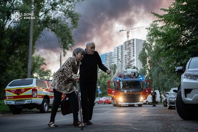 3∼4일 사이 러시아 공습 받은 키이우에서 두 노인이 길을 지나는 모습.