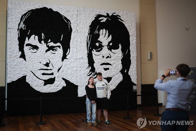 갤러거 형제 벽화 앞에서 기념촬영하는 팬들