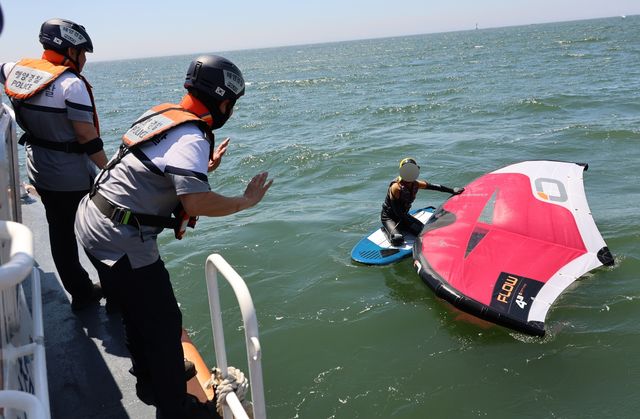 윙포일 레저객에게 홍보하는 해경