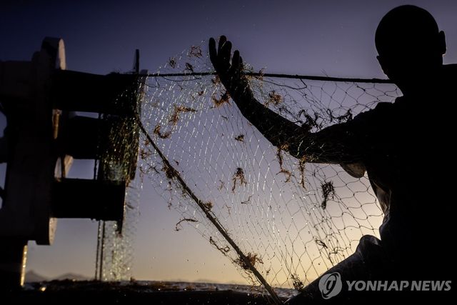 어망으로 조업하는 어민 