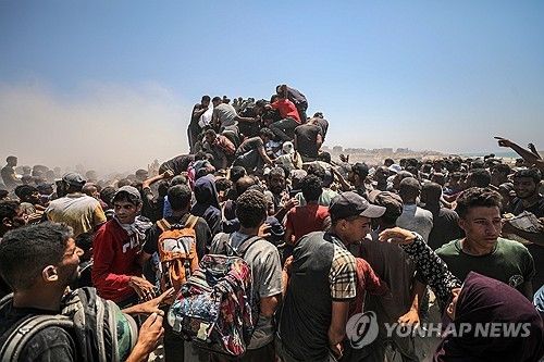 식량 배급소 인근에서 밀가루를 가져가려고 분투하는 가자 주민들 
