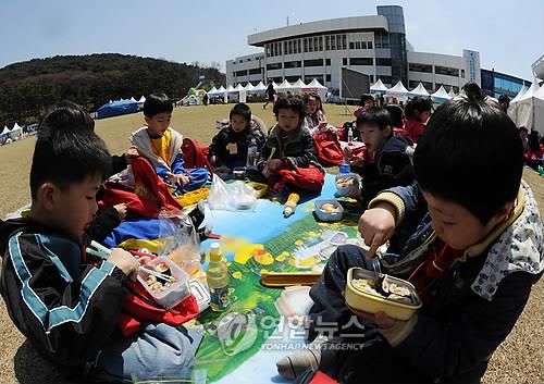 소풍 나와 잔디밭에서 김밥 먹는 아이들 
