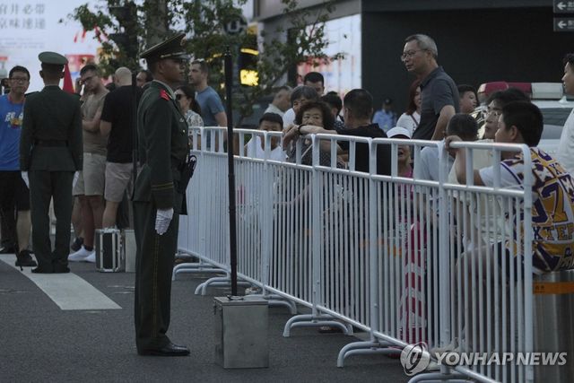 9일 저녁 중국 베이징 창안제에서 통행이 통제된 방문객·관광객들