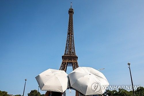 더위에 우산 쓴 관광객들 