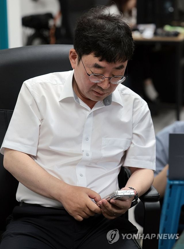 휴대전화 살펴보는 신혜식 대표