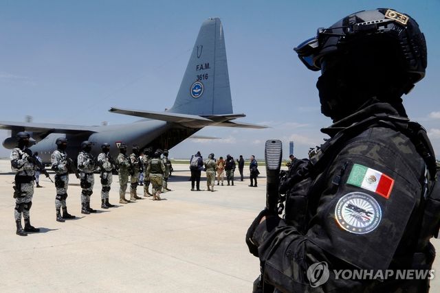 12일(현지시간) 카르텔 범죄자들의 미국 인도행 항공기 주변에 배치된 멕시코 장병