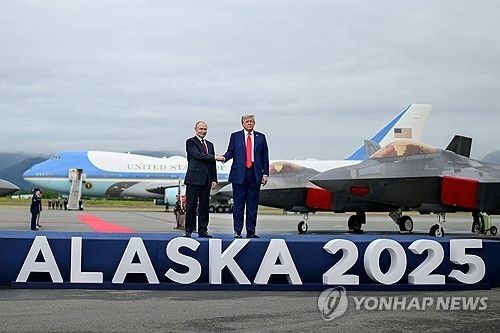미 공군 F-22 전투기가 도열된 활주로 무대에서 악수하는 트럼프와 푸틴 