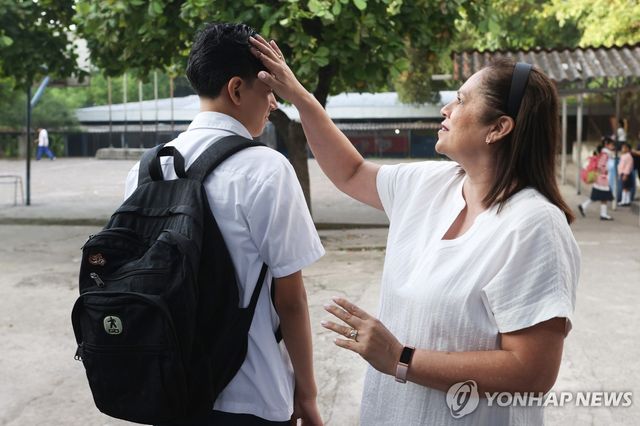 20일(현지시간) 학생 두발 상태 살피는 엘살바도르 학교 교장