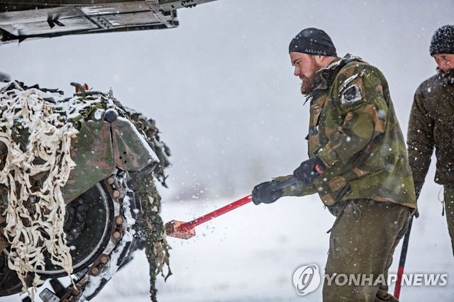 겨울철 탱크 훈련 중 장비 점검하는 노르웨이군 병사