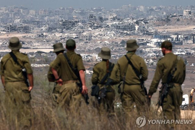 국경에서 파괴된 가자지구 바라보는 이스라엘 군인들