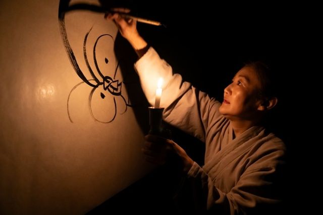 촛불을 들고 종이 뒤에서 그림을 그리는 문재현