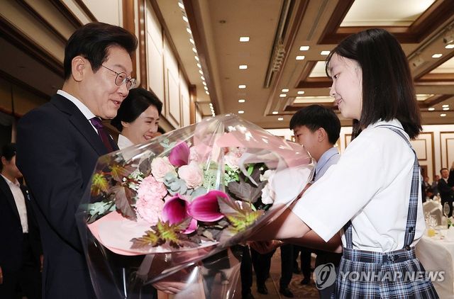 재일동포 간담회, 화동으로부터 꽃다발 받는 이재명 대통령 부부