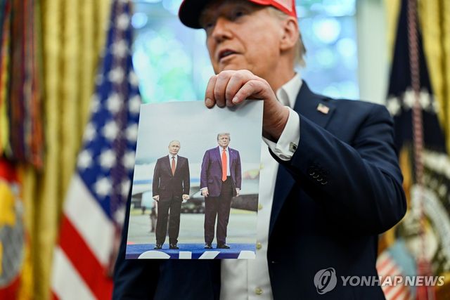 트럼프-푸틴 정상회담 사진 들어보이는 트럼프