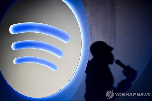 2024년 7월 멕시코시티에서 열린 스포티파이 발표회에 참석한 인공지능(AI) DJ 아나운서 재이비어 X 저니건의 그림자가 스포티파이 로고 옆에 비치고 있다. [AFP=연합뉴스 자료사진]