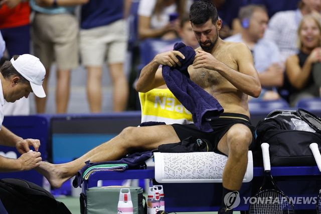 2세트 후 발 부위 치료를 받는 조코비치(오른쪽)