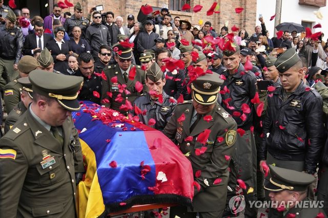 25일(현지시간) 반군 잔당 습격에 사망한 콜롬비아 경찰관 시신 운구