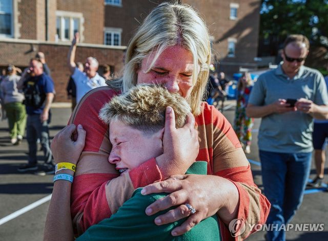 27일 총격 사건 발생한 미니애폴리스 가톨릭학교에서 포옹하는 엄마와 아들 