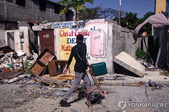 26일(현지시간) 아이티 수도 포르토프랭스에서 의자를 들고 귀가하는 주민