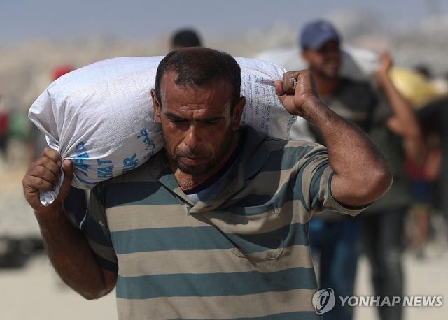 2일(현지시간) 가자지구 북부에서 배급받은 구호품을 들고 가는 팔레스타인 주민.[로이터=연합뉴스. 재판매 및 DB 금지]