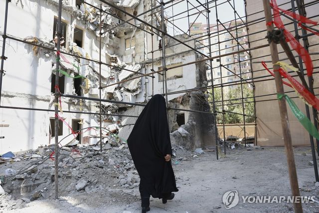 이란 테헤란에서 무너진 건물 사이를 지나가는 여성