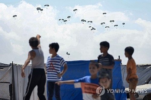 가자 남부 라파에서 어린이들이 구호품이 하늘에서 떨어지는 걸 지켜보고 있다. 
