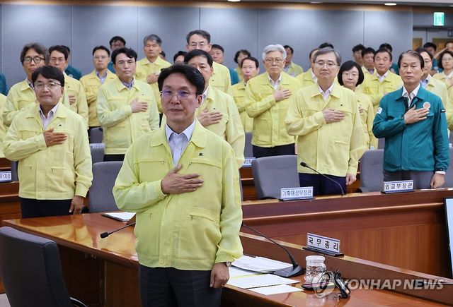 국기에 경례하는 김민석 총리와 참석자들