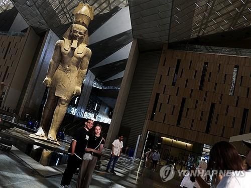 일부 전시실을 시범 운영 중인 이집트 대박물관의 람세스 2세 석상과 관람객