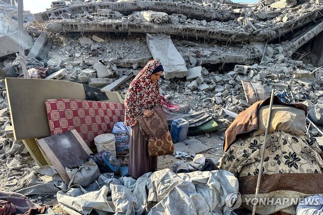 6일(현지시간) 이스라엘의 공습으로 파괴된 유엔 팔레스타인 난민구호기구(UNRWA) 건물 주변을 살펴보는 주민