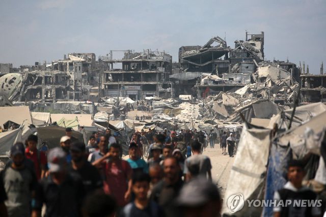 가자시티에서 무너진 건물 사이로 걷는 주민들