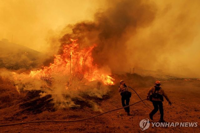 지난 7일 LA 북부 캐스테이크 지역에서 불길과 싸우고 있는 소방관들