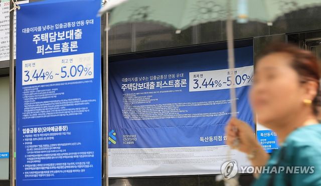 서울 시내 은행의 대출 홍보물 지나는 시민