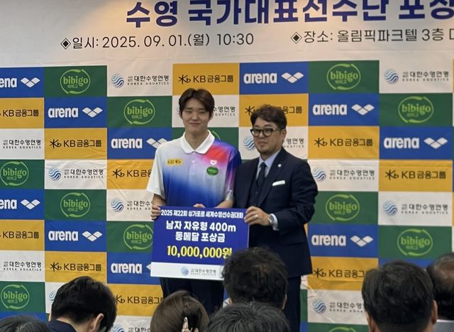 정창훈 연맹 회장(오른쪽)으로부터 상금을 받은 김우민