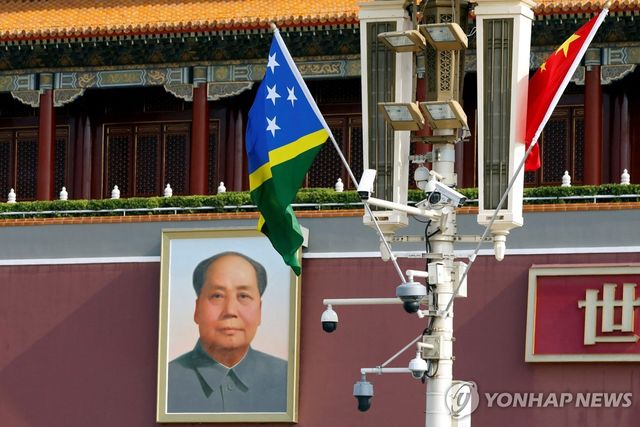 베이징 톈안먼의 마오쩌둥 초상화를 배경으로 중국과 솔로몬제도 국기가 걸려있는 모습.